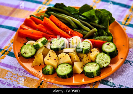 Siviera di vapore fresco raccolte verdure giovani compresi crinkle tagliare le carote affettate, piselli e manganelli di patate Foto Stock