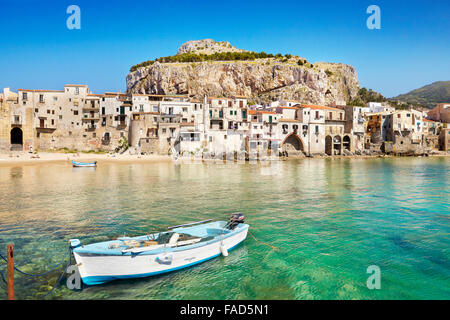 Barca da pesca e le case medioevali di Cefalù città vecchia, Sicilia, Italia Foto Stock