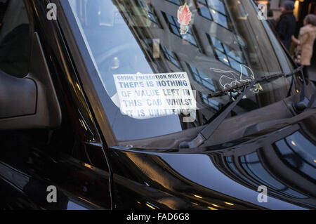 "Non vi è nulla di valore a sinistra in questa cabina mentre è incustodito' segno dentro Londra taxi nero il finestrino di cabina Foto Stock