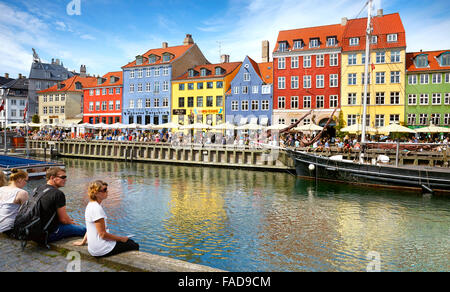 Turisti in appoggio a Nyhavn Canal, Copenhagen Città vecchia, Danimarca Foto Stock