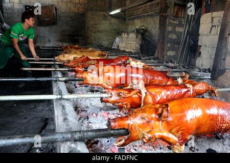 I lavoratori di Laloma in Quezon City (il lechon capitale delle Filippine) sta preparando il Lechon baboy (arrosto di maiale) che sono pronte per il ritiro per la prossima celebrazione del Noche-Buena o nuovo anno celebrazione, secondo l'lechonero (arrosto di maiale cook) cucinano il maiale arrosto da 2 a 3 ore e dipende dalle dimensioni e si continua a cuocere in modo tradizionale o la rotazione manuale della carne di maiale. I prezzi di Lechon baboy (arrosto di maiale) avviare da 4,00 pesos ogni fino a 15.000 ciascuno. (Foto di Gregorio B. Dantes Jr. / Pacific Stampa) Foto Stock