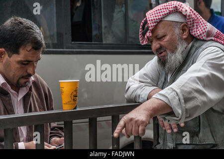 Due uomini arabi in abito moderno e gli altri in abito tradizionale, Amman, Giordania Foto Stock