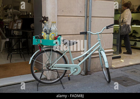 Bicicletta con bottiglie sul retro parcheggiato al di fuori di un negozio a Cadiz Spagna Foto Stock