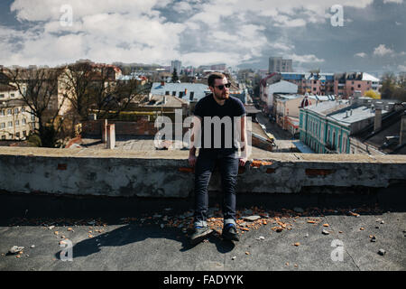 Fiducioso uomo in posa di cimosa jeans Foto Stock