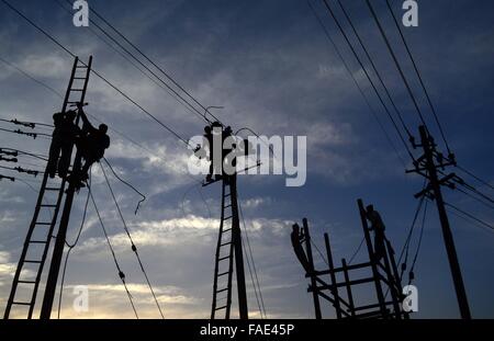 Di Allahabad, Uttar Pradesh, India. 28 dicembre, 2015. India, Uttar Allahabad: lavoratori indiani regolare i cavi elettrici impostato temporaneamente sulle rive del fiume Gange in preparazione per l'annuale religiosi indù fiera di Magh Mela a Allahabad su dicembre 28, 2015. Il Magh Mela si svolge ogni anno sulle rive del Triveni Sangam - la confluenza dei tre grandi fiumi Ganga, Yamuna e la mistica Saraswati durante il mese indù di Magh che corrisponde a metà gennaio - Metà febbraio © Prabhat Kumar Verma/ZUMA filo/Alamy Live News Foto Stock