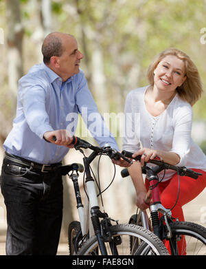 Sorridente famiglia internazionale di pensionati attivi con le bici per esterno Foto Stock