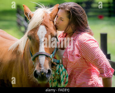 Donna baciare il suo cavallo Foto Stock