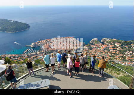 I turisti su una piattaforma di avvistamento con la Città Vecchia e la fortezza nella distanza, Dubrovnik, Croazia. Foto Stock