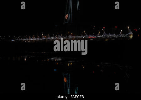 Notte obliqua vista spiaggia, con riflessioni, per Bling luminarie e cuore rosa Blackpool Tower, Central Promenade, Blackpool Foto Stock