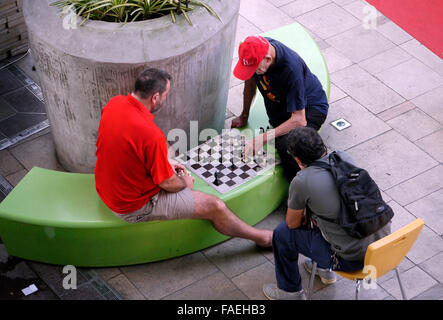Due maschi aventi un gioco di scacchi che è riprodotto all'esterno in uno spazio pubblico Foto Stock