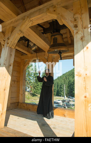 Un giovane sacerdote gli anelli a campana Foto Stock