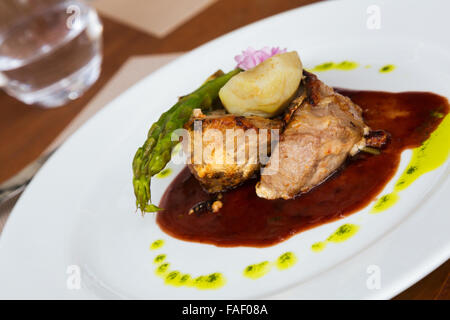 Costolette di agnello grigliate con salsa di pomodoro e verdure al ristorante Foto Stock
