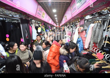 (151229) -- PECHINO, Dic 29, 2015 (Xinhua) -- residenti scramble per l'acquisto di capi di abbigliamento al Julong Foregin Trade indumento in negozio lo Zoo Area di Mercato nel centro cittadino di Xicheng District a Pechino Capitale della Cina, Dic 29, 2015. Il Julong Commercio Estero indumento città sarà chiuso il 31 dicembre, una mossa del governo di Pechino per spostare progressivamente i mercati nel Zoo Area di mercato ai paesi limitrofi nella provincia di Hebei in modo da ridurre la congestione di traffico e la densità della popolazione nella capitale. Il trasferimento avrà infine liberare 300.000 metri quadrati e spostarsi di circa 30.000 lavoratori a meno affollata di periferia. Foto Stock