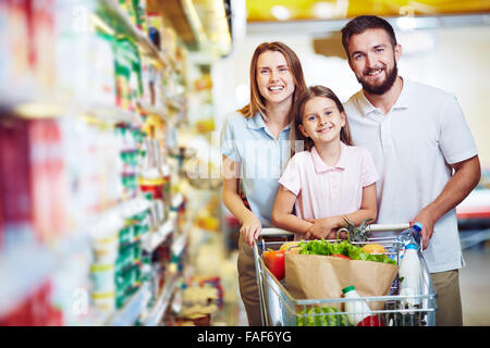 Famiglia con trinciatura di carrello durante la spesa al supermercato vegetale Foto Stock