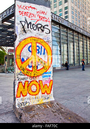 Berlino, Germania - un pezzo storico di Berlino muro con graffiti e simbolo di pace a Potsdamer Platz di Berlino Foto Stock