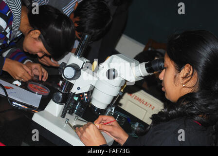 Studenti che lavorano nel laboratorio di biologia con microscopio Foto Stock