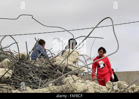 Gerusalemme, Territorio palestinese. 29 Dic, 2015. Bambini palestinesi stand sulle macerie della loro casa che fu demolita da Gerusalemme comune di lavoratori in Gerusalemme, Dicembre 29, 2015. Case palestinesi costruite senza un israeliano del permesso di costruzione sono spesso demolita per ordine del comune di Gerusalemme Credito: Mahfouz Abu Turk/immagini APA/ZUMA filo/Alamy Live News Foto Stock