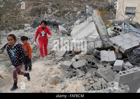 Gerusalemme, Territorio palestinese. 29 Dic, 2015. Bambini palestinesi stand sulle macerie della loro casa che fu demolita da Gerusalemme comune di lavoratori in Gerusalemme, Dicembre 29, 2015. Case palestinesi costruite senza un israeliano del permesso di costruzione sono spesso demolita per ordine del comune di Gerusalemme Credito: Mahfouz Abu Turk/immagini APA/ZUMA filo/Alamy Live News Foto Stock