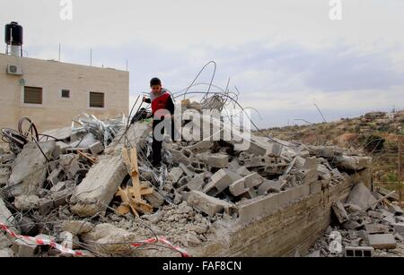 Gerusalemme, Territorio palestinese. 29 Dic, 2015. Bambini palestinesi stand sulle macerie della loro casa che fu demolita da Gerusalemme comune di lavoratori in Gerusalemme, Dicembre 29, 2015. Case palestinesi costruite senza un israeliano del permesso di costruzione sono spesso demolita per ordine del comune di Gerusalemme Credito: Mahfouz Abu Turk/immagini APA/ZUMA filo/Alamy Live News Foto Stock