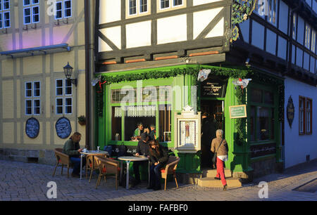 I turisti sedersi fuori il Roland Cafe in Quedlinburg, Germania, 29 dicembre 2015. Ci sono più di 1.200 edifici con travi in legno di varie età nel patrimonio mondiale UNESCO Città. Foto: Jens WOLF/ZB Foto Stock