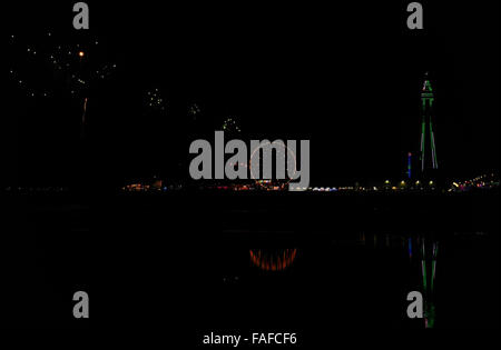 Centrale di notte Sands Beach view, con riflessioni e a verde Blackpool Tower, fuochi d'artificio su Central Pier di Blackpool luminarie Foto Stock