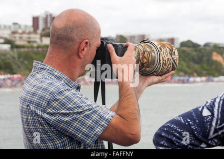 Fotografo con grande lente lungo per catturare l'azione a Bournemouth Air Festival nel mese di agosto Foto Stock