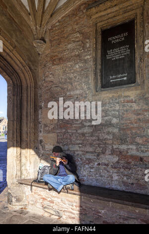 Un musicista itinerante suonare il flauto nel portico squattrinati nella cattedrale della città di pozzetti, Somerset REGNO UNITO Foto Stock