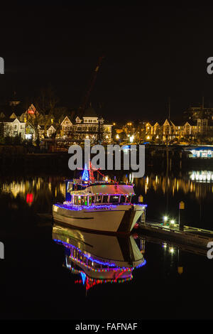 Barca a motore nel porto Victoria durante la notte con le luci di Natale Foto Stock