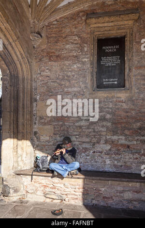 Un musicista itinerante suonare il flauto nel portico squattrinati nella cattedrale della città di pozzetti, Somerset REGNO UNITO Foto Stock