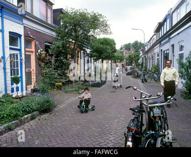 Cicli e i ciclisti in Anthonie Camerlingstraat, un vecchio traffico-bambino gratis-friendly street a Dordrecht, Paesi Bassi. Foto Stock