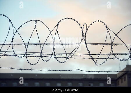 Filo spinato teso intorno le mura della prigione Foto Stock