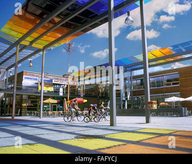 I ciclisti nella piazza centrale di Pichling città solare, un nuovo sobborgo di uno sviluppo sostenibile sul bordo di Linz, Austria. Foto Stock