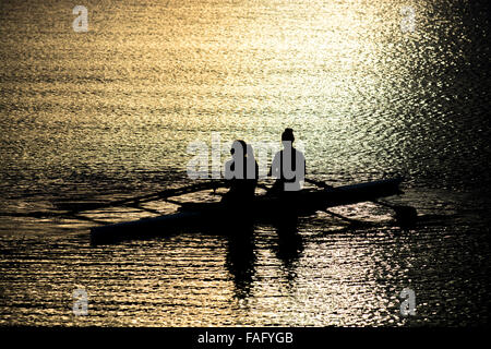 Canottiere Femminili In Una Scultura Doppia Sul Lago Sunset Foto Stock