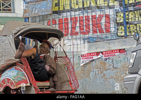 Un Becak conducente assume un pisolino di pomeriggio il calore Foto Stock