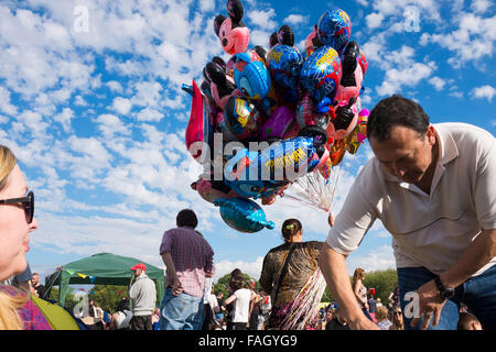 Vendita di palloncini in mezzo alla folla durante l annuale Africa Oye festival di Liverpool, uno dei più grande del Regno Unito free festival musicali estivi Foto Stock