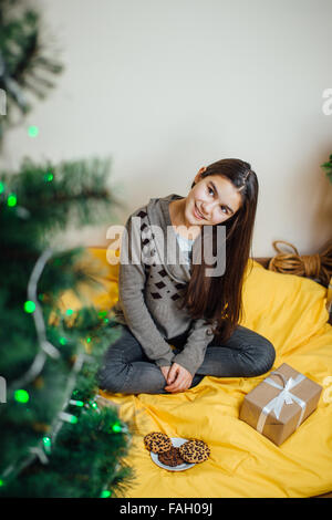 Bambina azienda presenta e sorridente Foto Stock