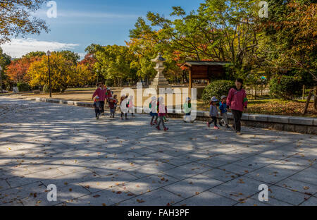 I bambini e gli adulti a piedi attraverso il Hiroshima Peace Memorial Park, un parco dedicato alla promozione della pace di Hiroshima in Giappone Foto Stock