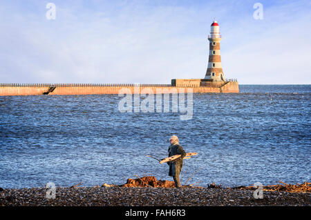 Uomo anziano raccogliendo driftwood su Roker Beach Foto Stock