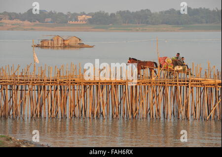 Cavallo di overload carrello attraversa il ponte di bambù sul fiume Mekong (houseboat in background), Kampong Cham, Cambogia. Credito: Kraig Lieb Foto Stock