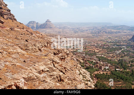 Yemen, natura e paesaggio: rocce rosse e villaggi, panoramica della valle di Shibam visto da Kawkaban, città fortificata a nord-ovest di Sana'a Foto Stock