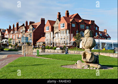 Millennium statua scultura in alto a bay area, Robin Hood's Bay, North Yorkshire, Regno Unito Victoria Hotel in background Foto Stock