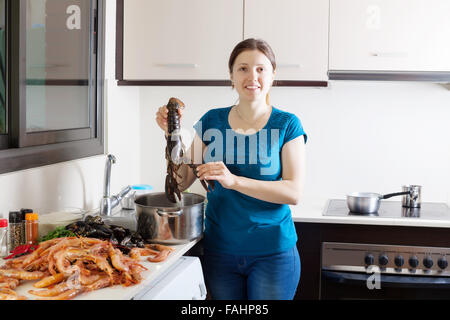 Ragazza la cottura di alimenti di mare Specialità in cucina Foto Stock