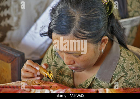 Femmina lavoratore Batik applicando oro per tessuto Foto Stock