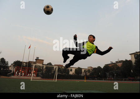 Hefei, cinese della provincia di Anhui. 29 Dic, 2015. Allievo Yang Minhui calci un calcio in cielo in una scuola primaria per salutare il nuovo entrante anno nella città di Hefei, Cina orientale della provincia di Anhui, Dic 29, 2015. © Zhang Hongjin/Xinhua/Alamy Live News Foto Stock