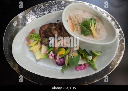 Lo Chef Bo Songvisava, il miglior chef donna in Asia nel suo ristorante Bo Lan in Bangkok. Thailandia. Duck rousted e condimento salato Foto Stock