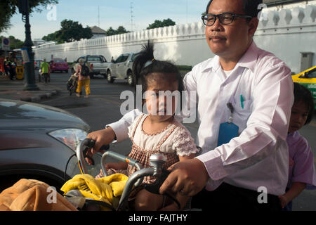 Poco ragazzi e suo padre il loro moto al di fuori del Wha Pho tempio di Bangkok, Tailandia. Foto Stock