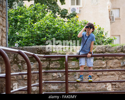 I giovani di osservazione degli uccelli un ragazzino di sette con un binocolo Foto Stock