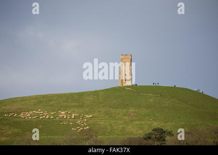 Glastonbury, Somerset, Regno Unito. Il 31 dicembre, 2015. Centinaia di persone che fanno il pellegrinaggio Vigilia di Capodanno al top di Glastonbury Tor nonostante i forti venti e minaccia di docce a pioggia. Molte più persone rimarranno sul fianco di una collina che si affaccia sulla pianura alluvionale del Somerset per vedere la prima alba del 2016. Credito: Wayne Farrell/Alamy Live News Foto Stock