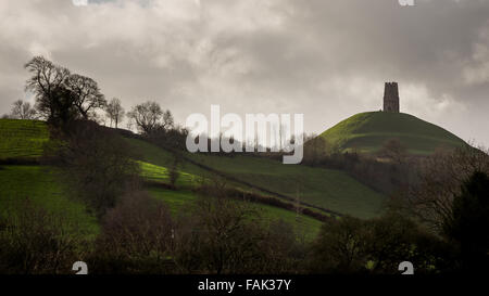Glastonbury, Somerset, Regno Unito. Il 31 dicembre, 2015. Centinaia di persone che fanno il pellegrinaggio Vigilia di Capodanno al top di Glastonbury Tor nonostante i forti venti e minaccia di docce a pioggia. Molte più persone rimarranno sul fianco di una collina che si affaccia sulla pianura alluvionale del Somerset per vedere la prima alba del 2016. Credito: Wayne Farrell/Alamy Live News Foto Stock