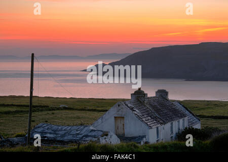 Traditional Irish cottage sulla penisola Mizen al crepuscolo, Beara in background Foto Stock